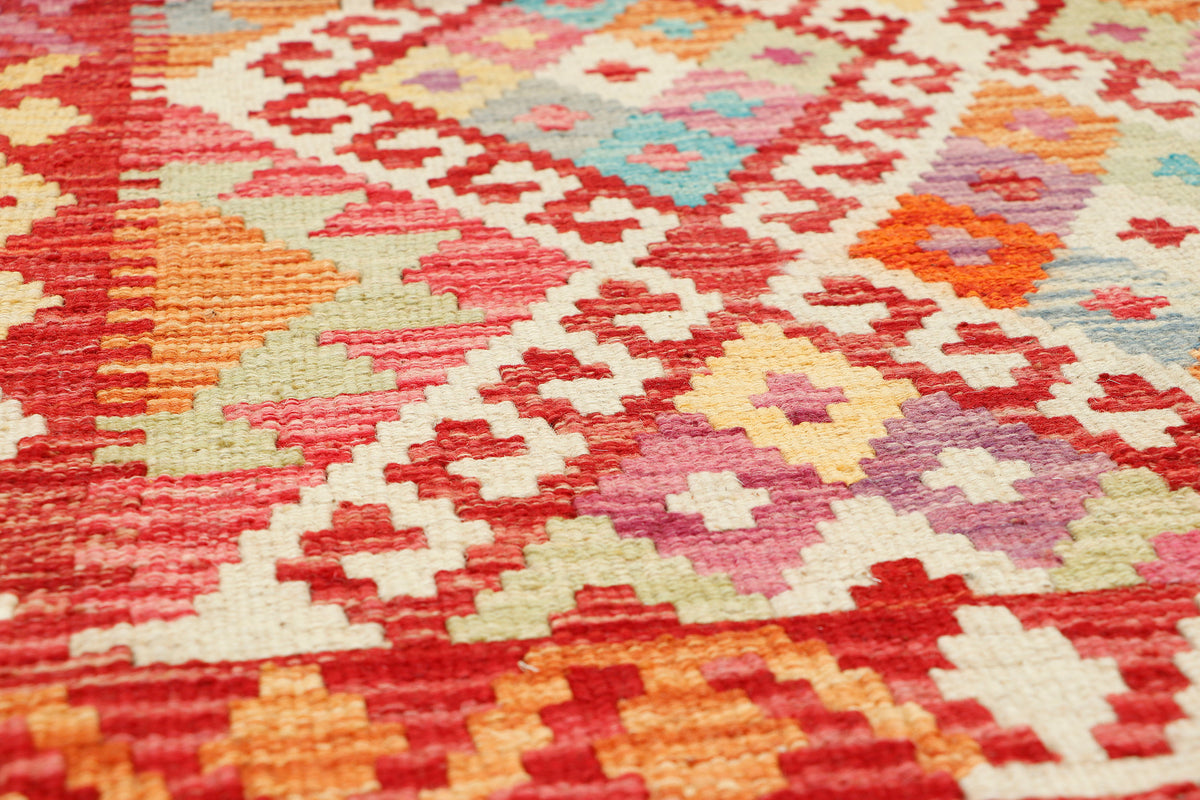Afghan Kilim rug by eastofhere, 124x88cm, with geometric patterns and vibrant colors, displayed on a wooden floor.