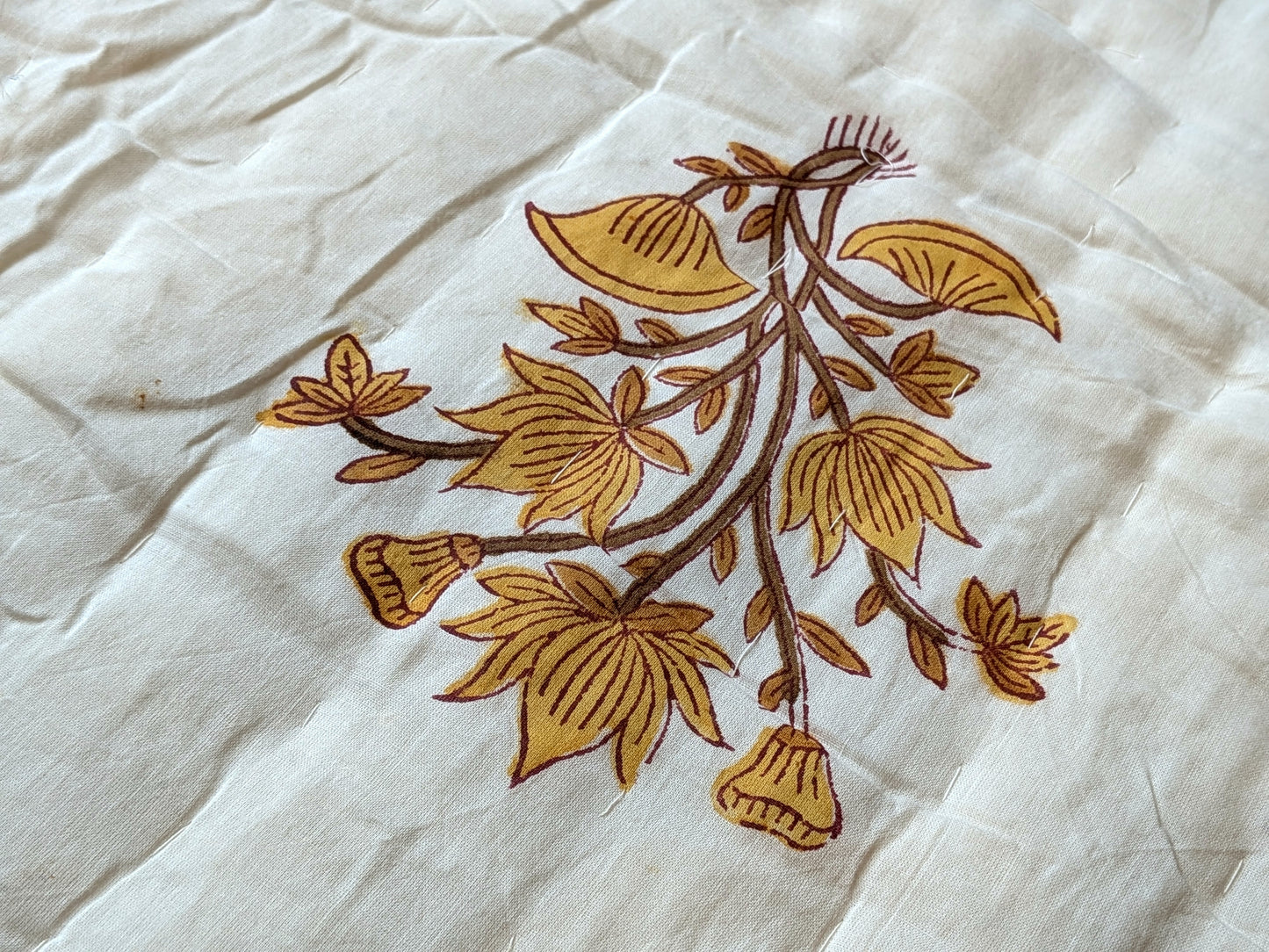 Brown floral embroidery on a white fabric background