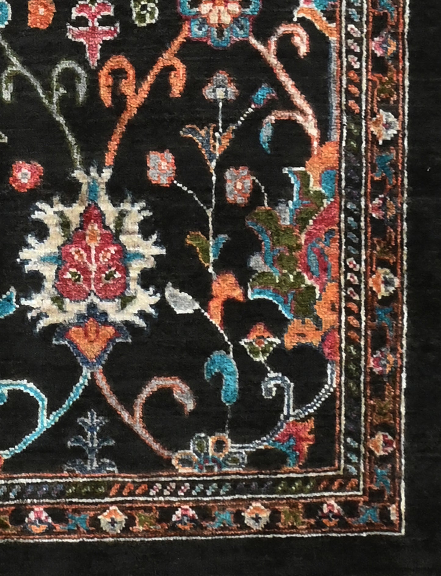Decorative rug corner with intricate floral patterns on a black background