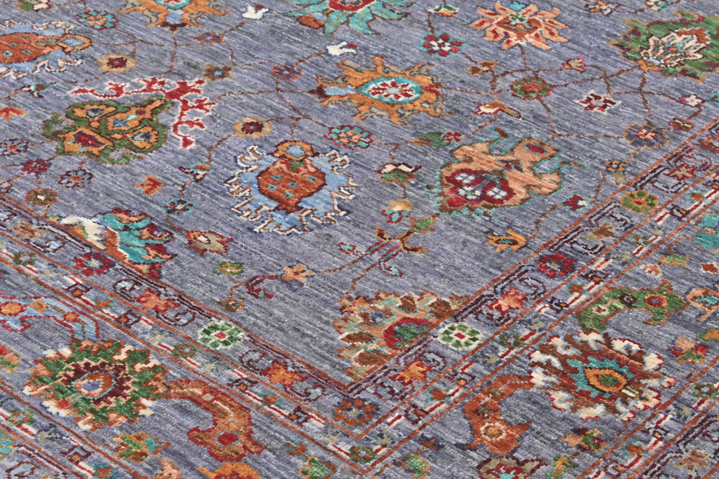 Close-up of a patterned rug with intricate designs on a blue background