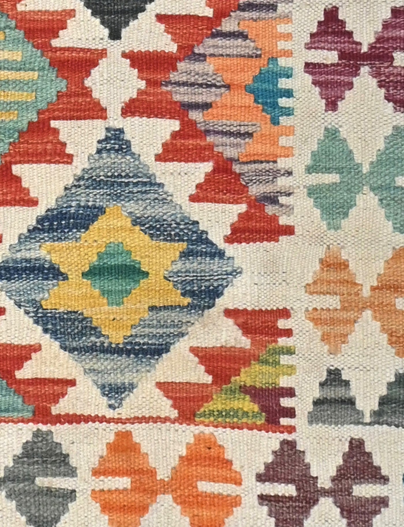Close-up of a colorful geometric patterned fabric with diamond shapes and star-like design.