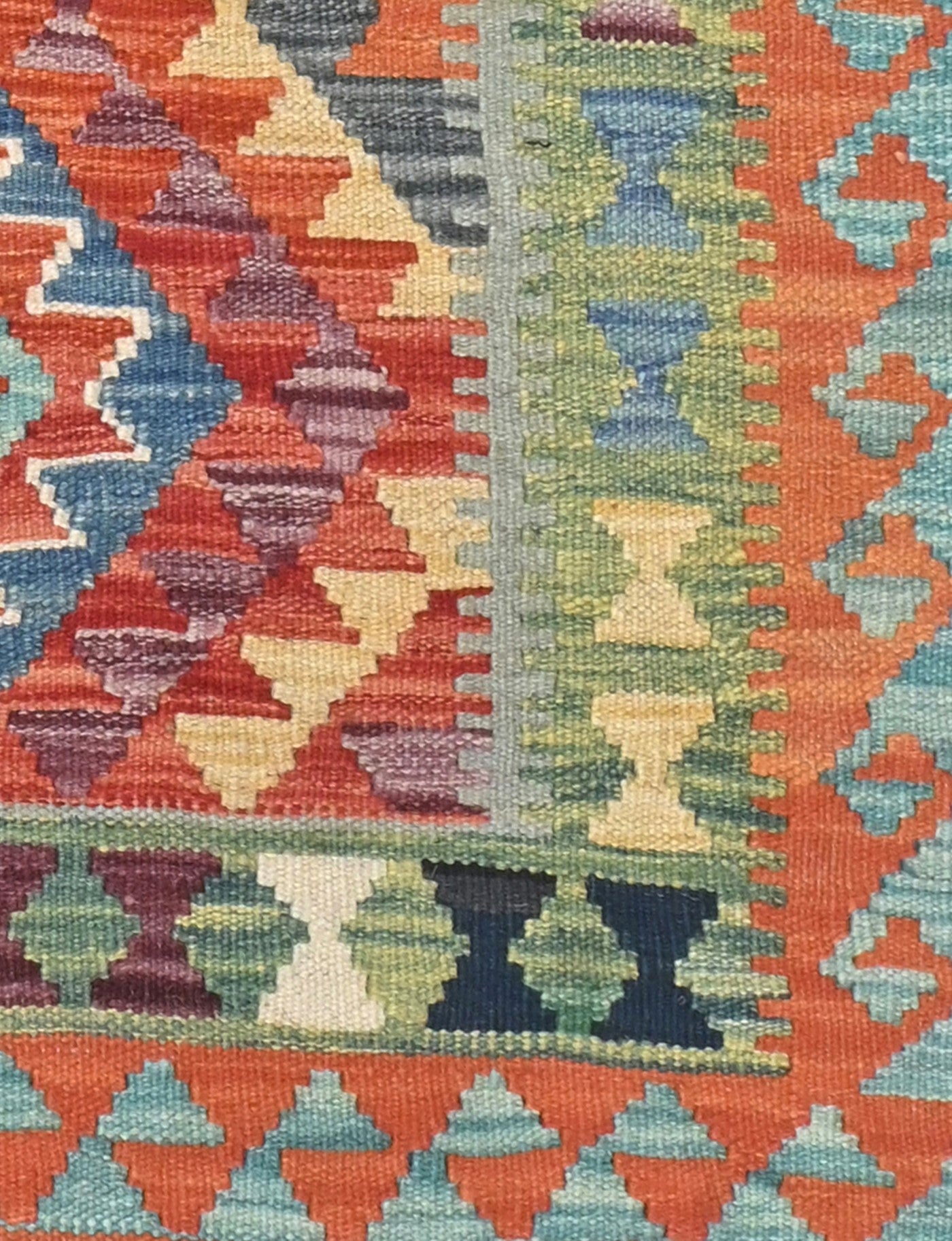 Close-up of a colorful geometric patterned rug with vibrant colors.