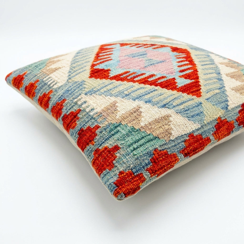 Colorful kilim cushion by eastofhere with intricate geometric patterns, showcasing rich textile craftsmanship.