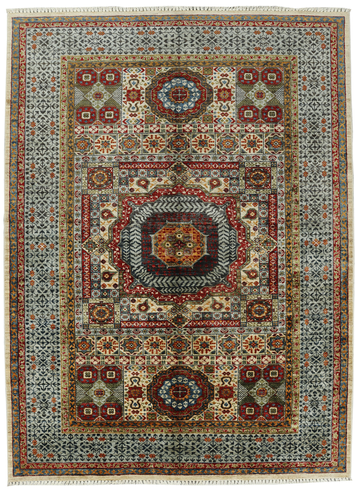 A traditional rectangular area rug with an intricate geometric and floral medallion pattern, featuring a central medallion, multiple borders, and white fringe on the top and bottom edges.