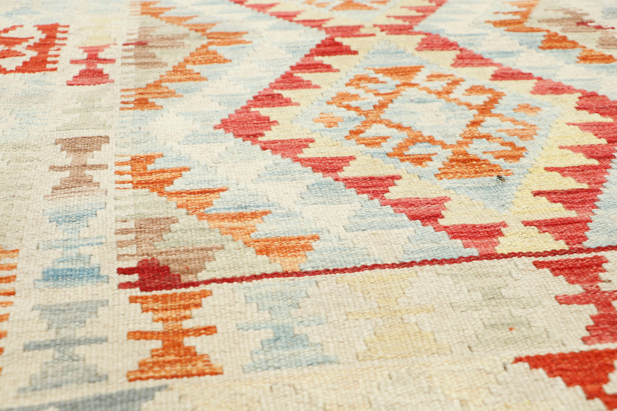 Afghan Kilim rug by eastofhere, 116x79cm, featuring traditional geometric patterns in vibrant colors, displayed on a neutral floor.