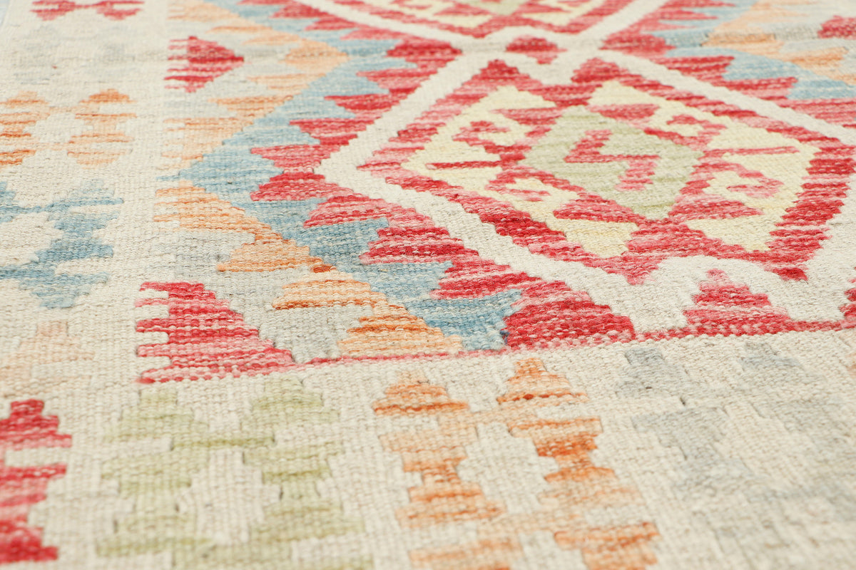 Afghan Kilim rug with geometric patterns in vibrant colors, measuring 108x76cm, by eastofhere, laid out on a wooden floor.