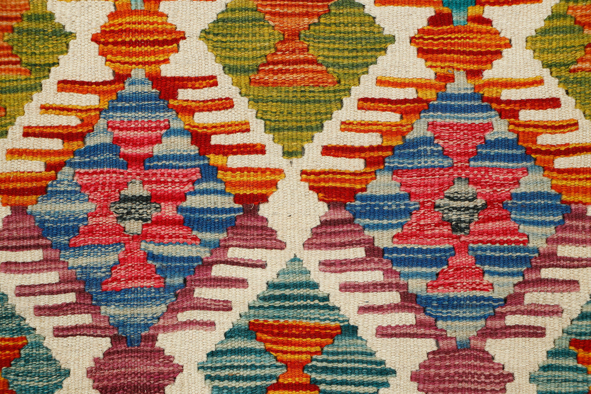 Afghan Kilim runner rug by eastofhere with geometric patterns in vibrant colors, measuring 142x64cm.