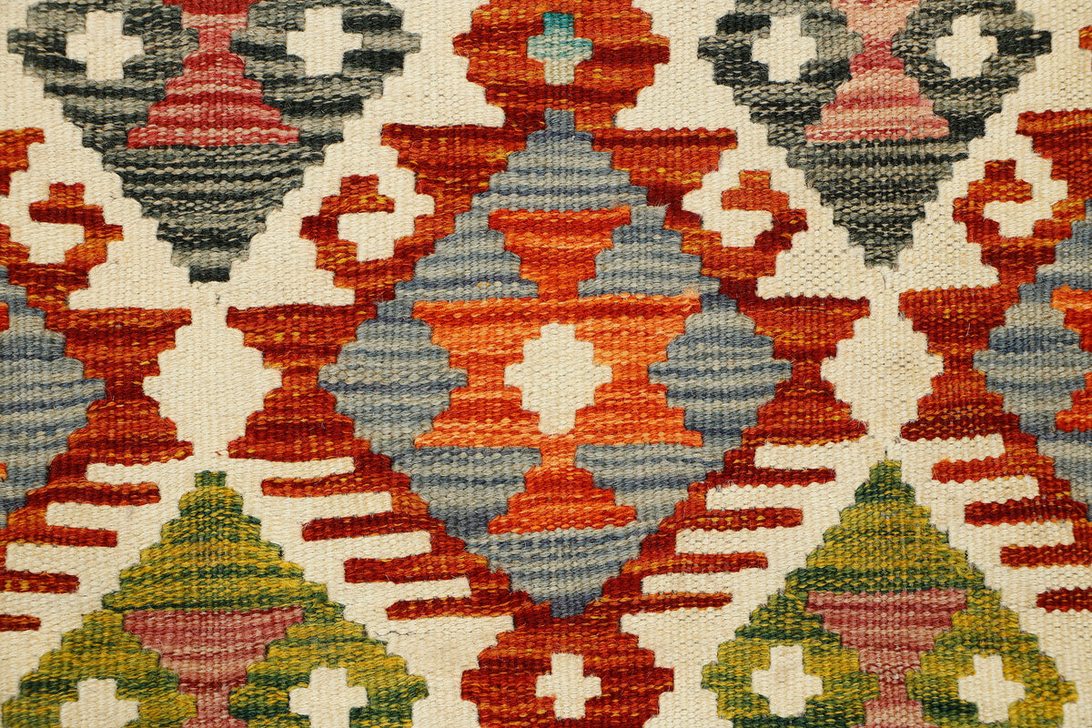 Afghan Kilim runner rug by eastofhere, 145x57cm, featuring traditional geometric patterns and vibrant earthy tones.