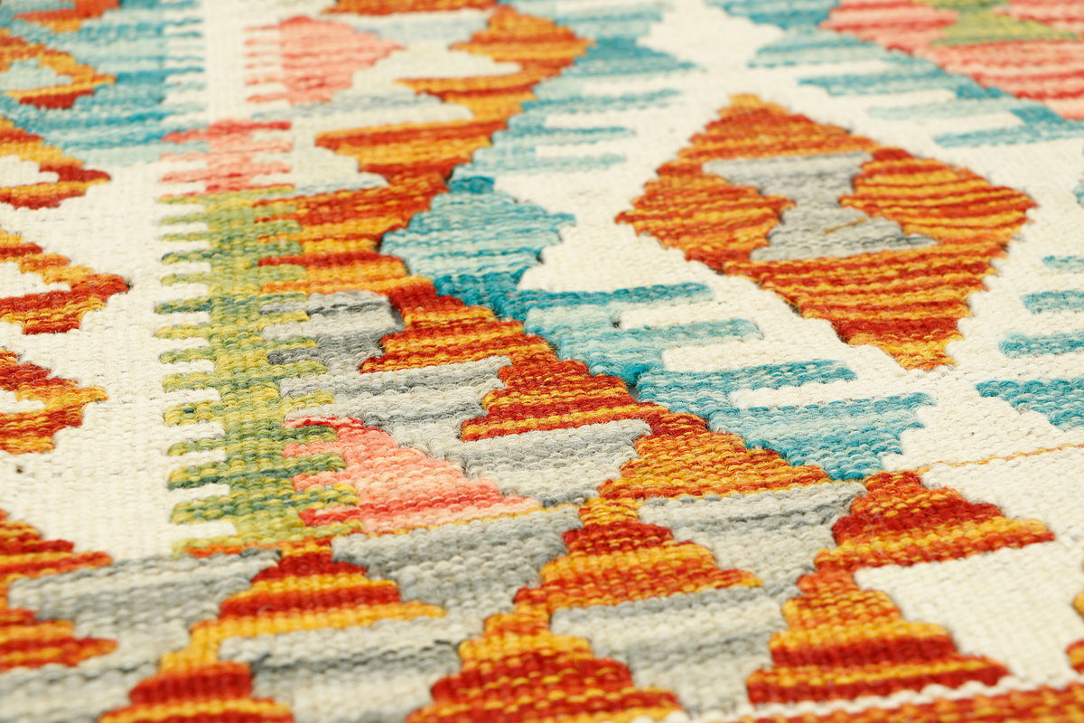 Afghan Kilim rug runner by eastofhere, 133x63cm with vibrant geometric patterns on a woven textile background.