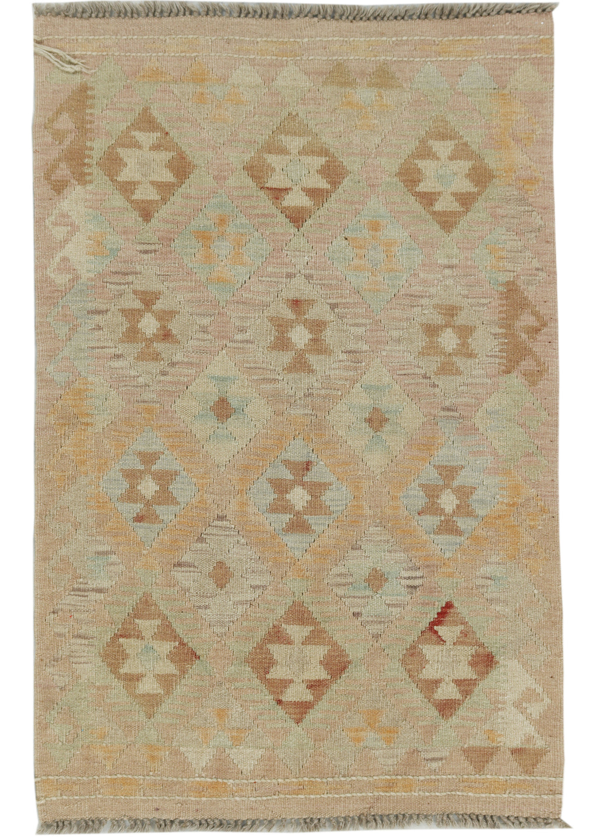 A hand woven rug with a geometric diamond pattern in beige, tan, muted brown, and soft sage green tones, featuring fringed edges.