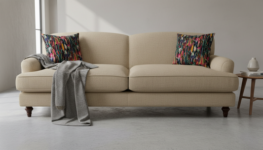 Tamarisk, Claudette, Beige sofa with colorful cushions and a blanket in a minimalistic room.