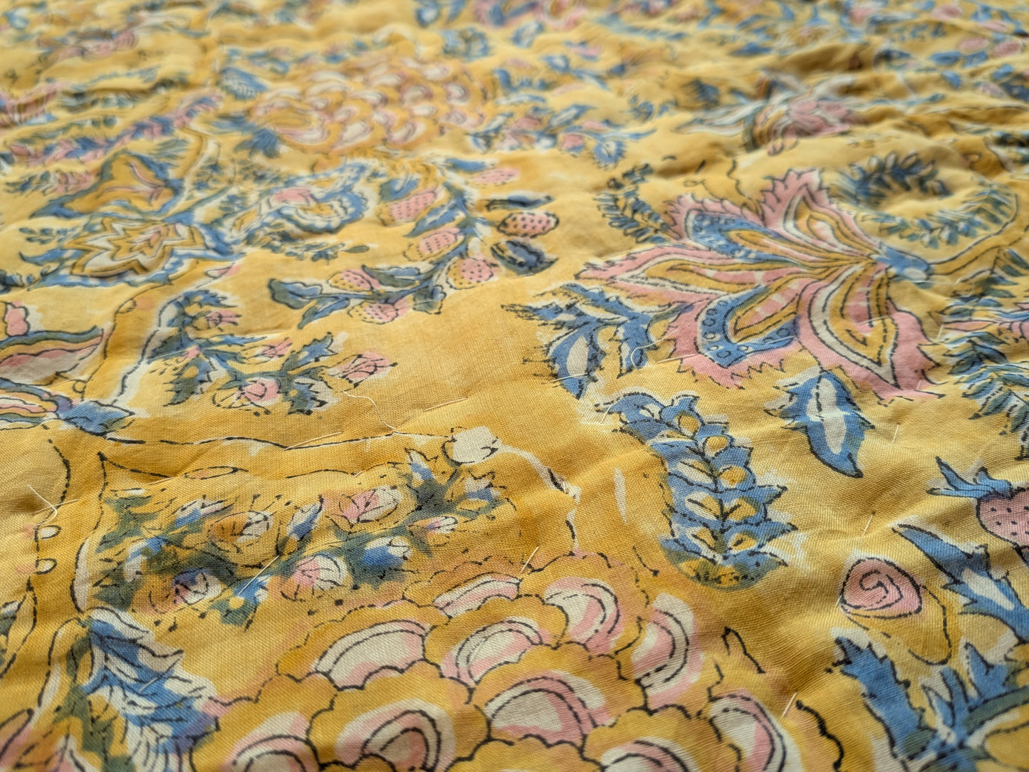 Close-up of a yellow fabric with intricate floral patterns