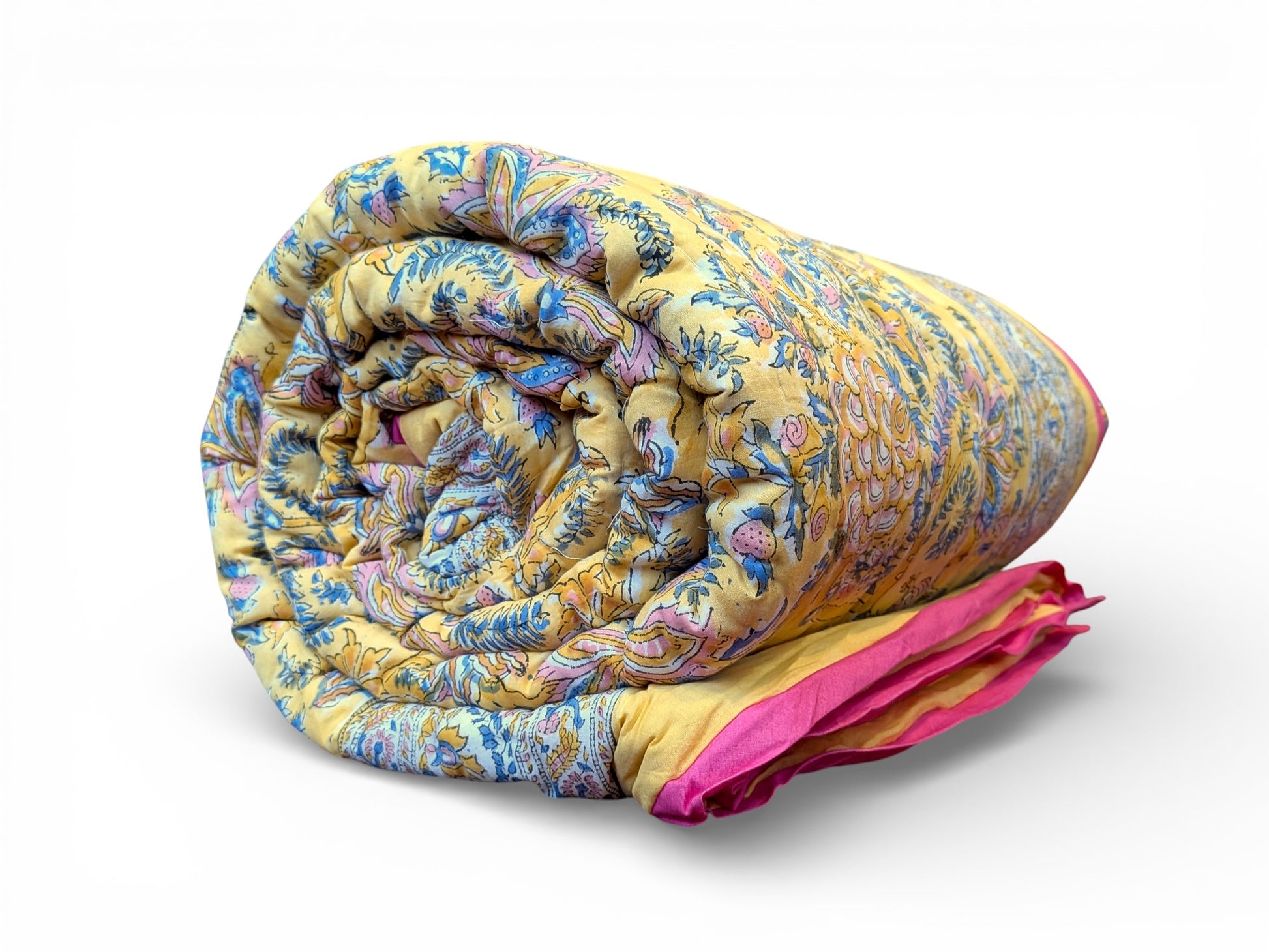 Rolled-up colorful quilt with a pink corner on a white background