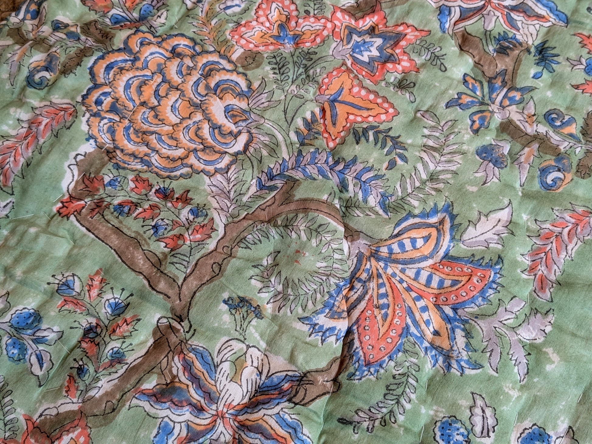 Close-up of a floral and tree design on a textured fabric background