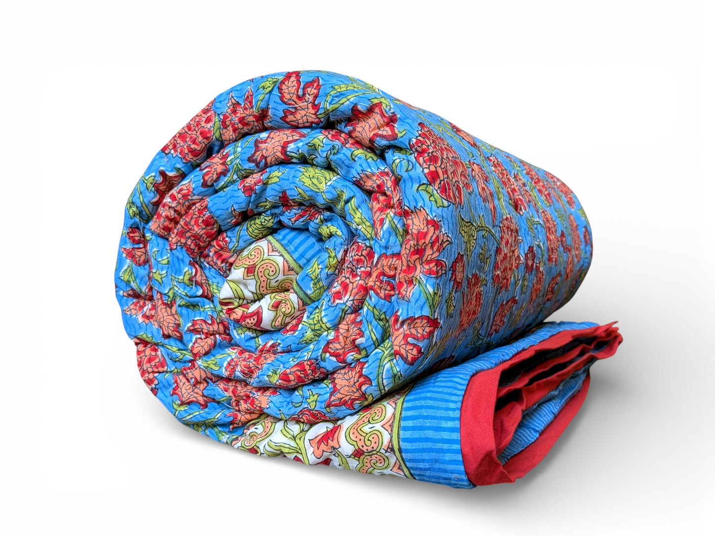 Rolled-up floral quilt with red and blue patterns on a white background