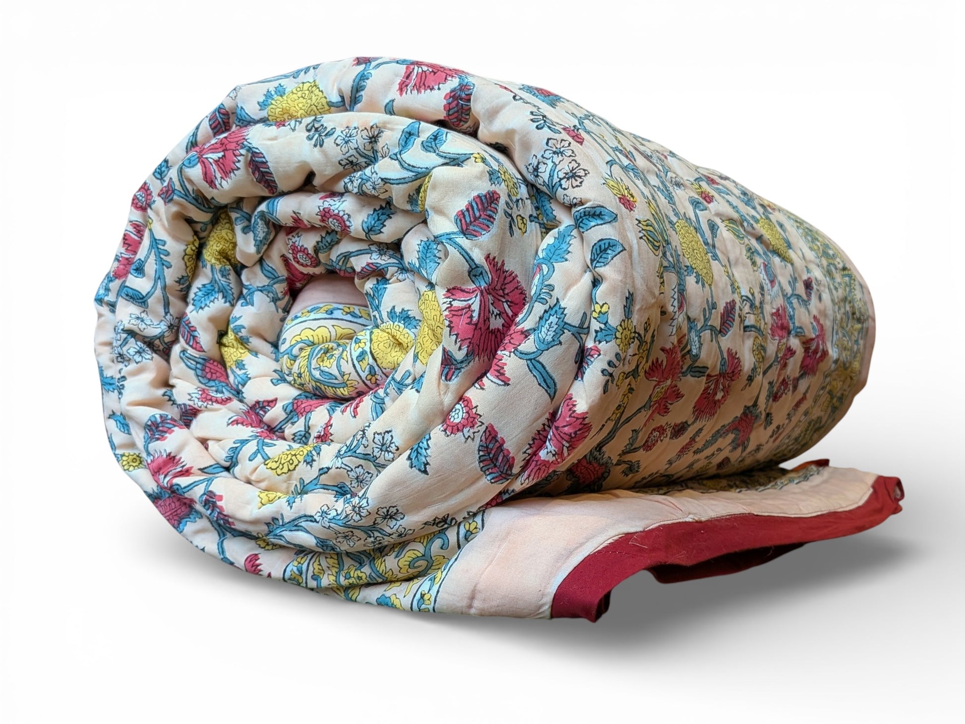 Rolled-up floral quilt with colorful patterns on a white background