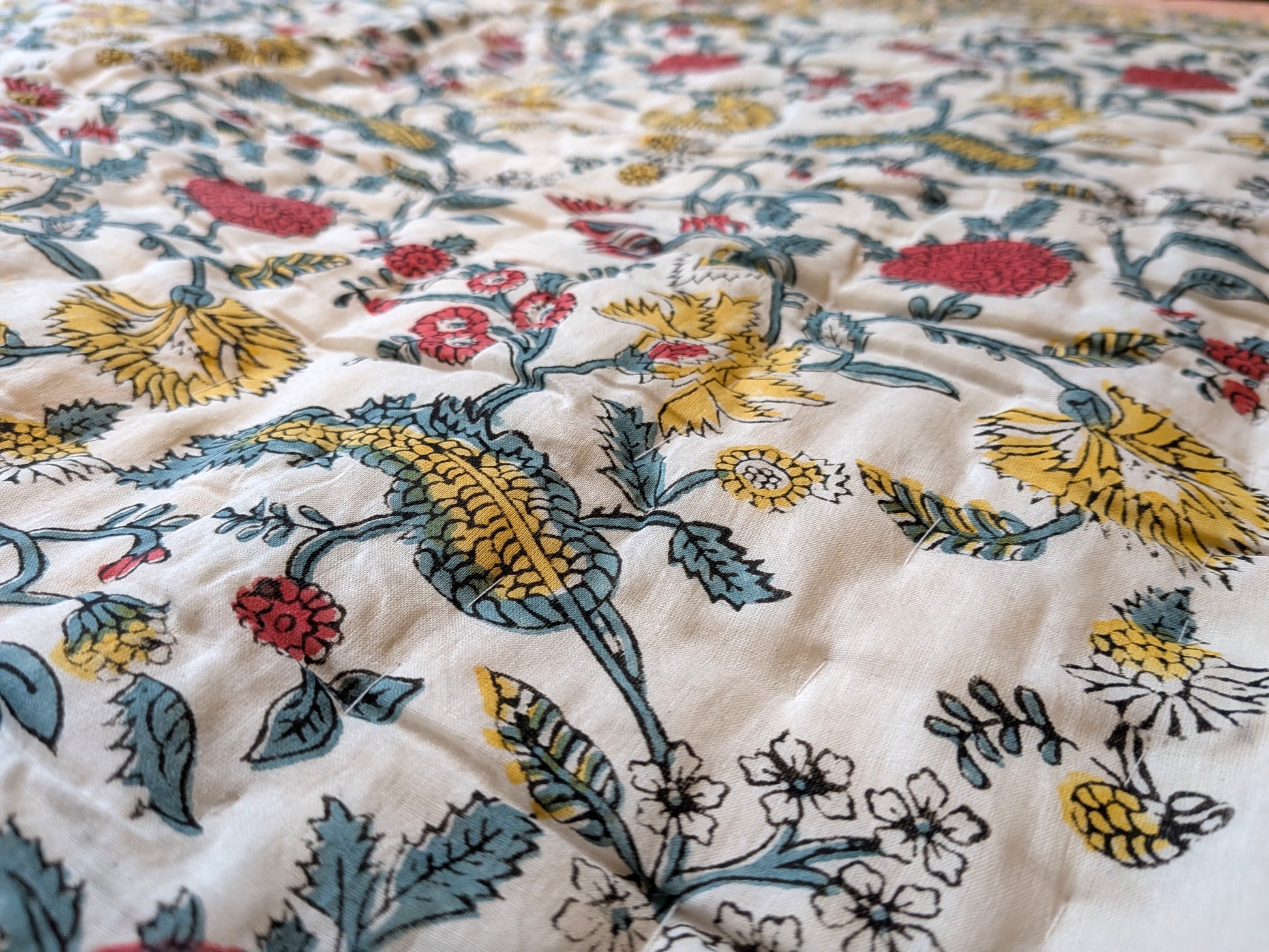 Close-up of a floral patterned fabric with colorful flowers and leaves.