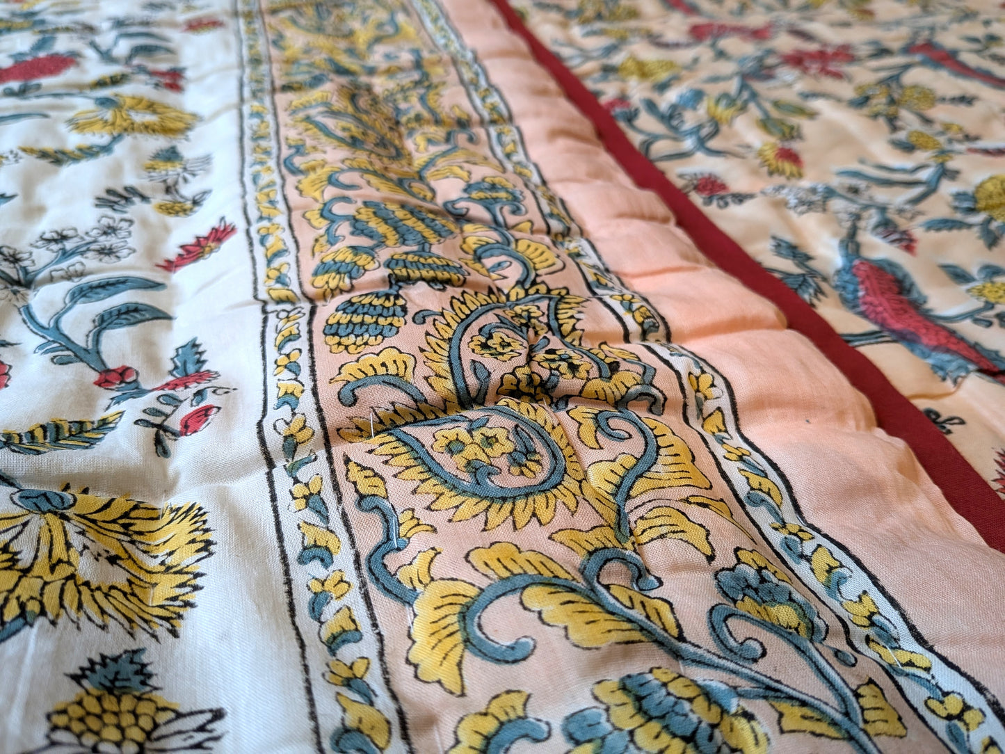 Close-up of patterned fabric with intricate designs in yellow, blue, and red.