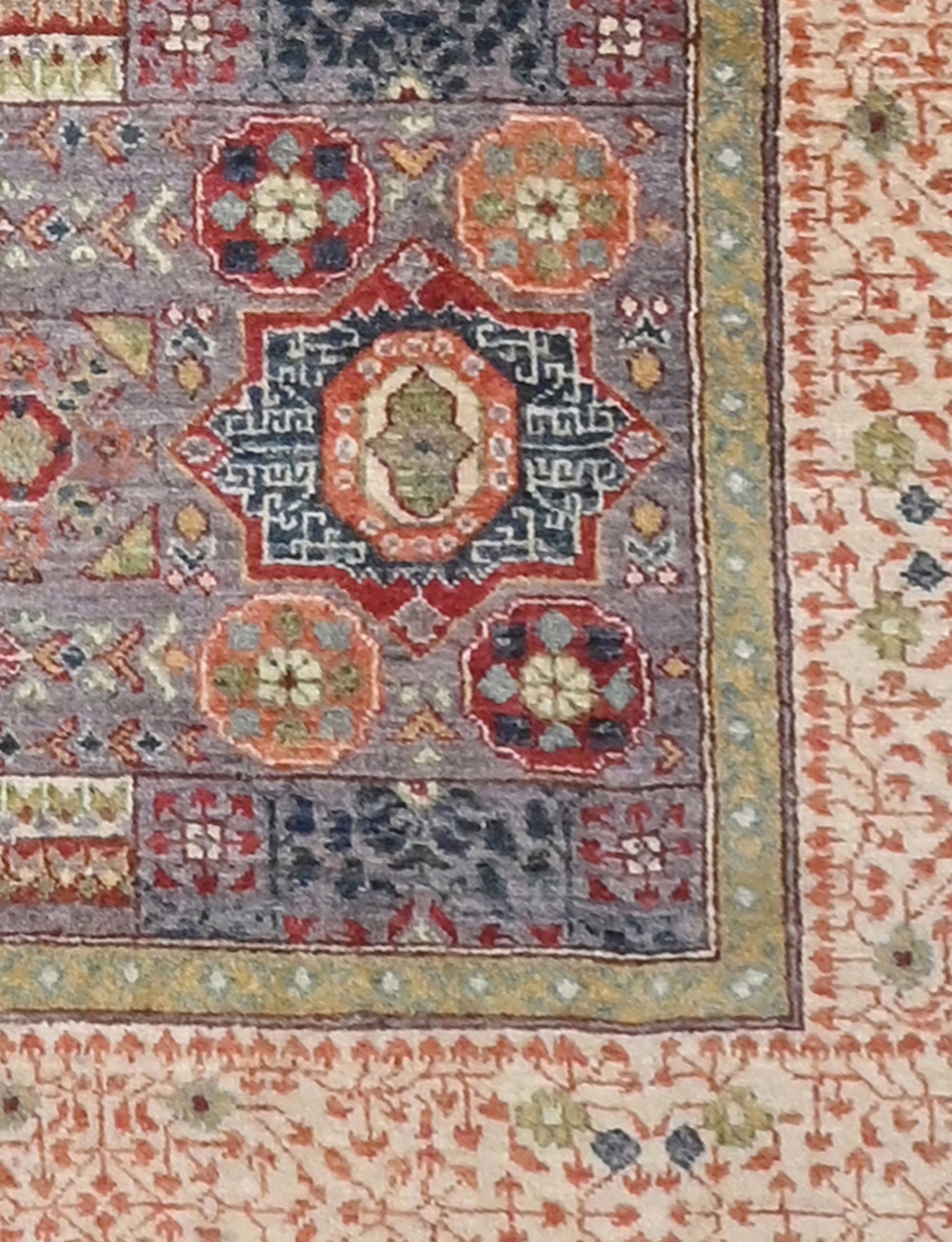 Close-up of a patterned rug with intricate designs in various colors.