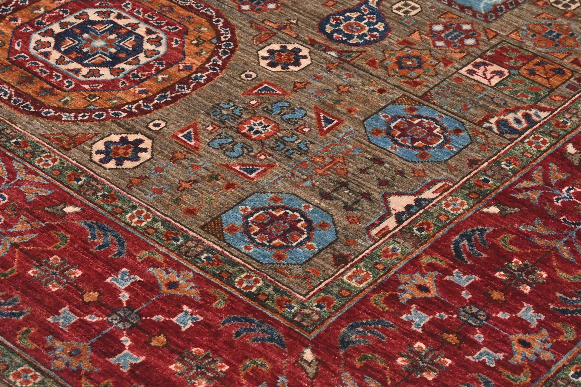 Close-up of a patterned rug with geometric designs in red, blue, and brown.