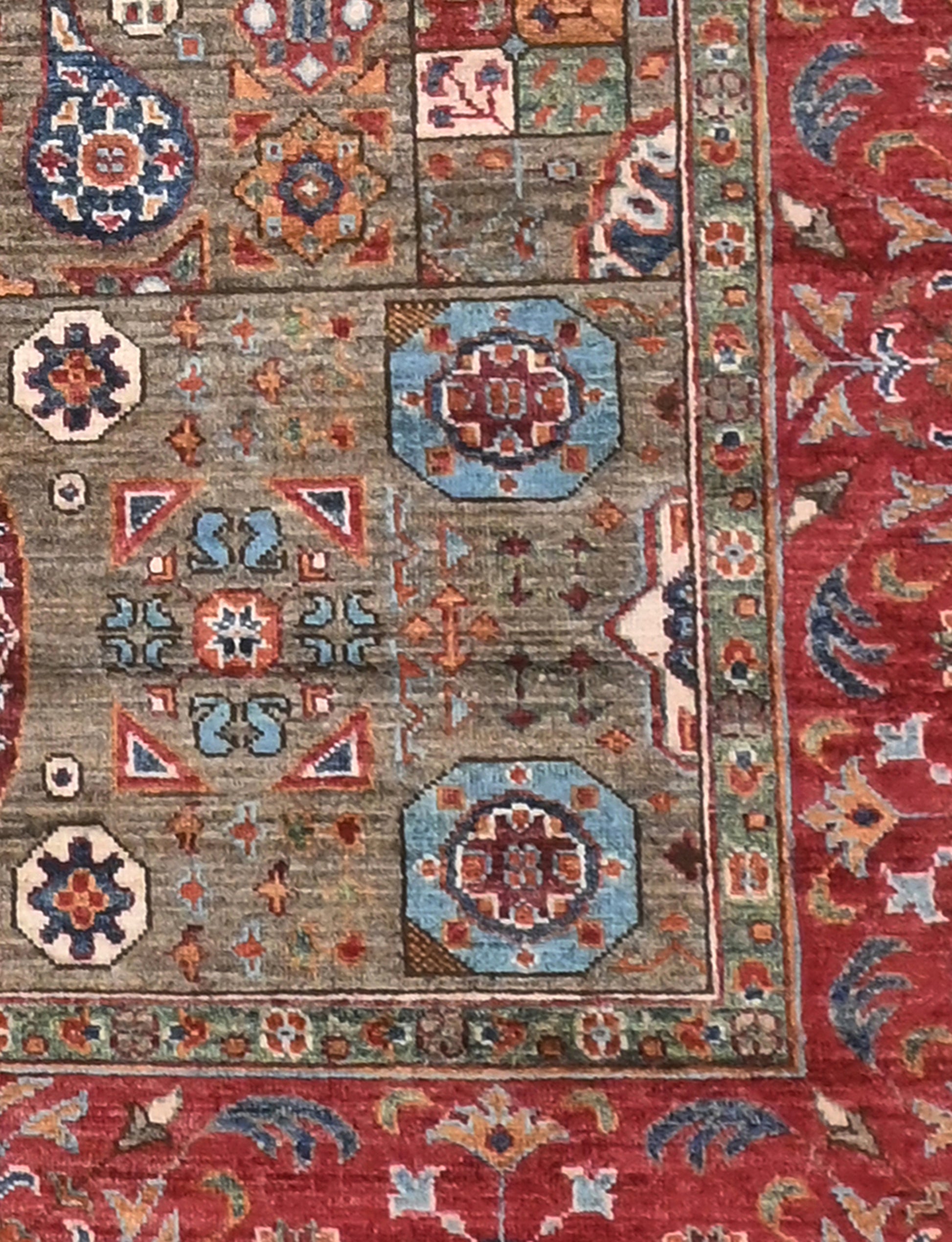 Close-up of a patterned rug with geometric designs in red, blue, and brown.