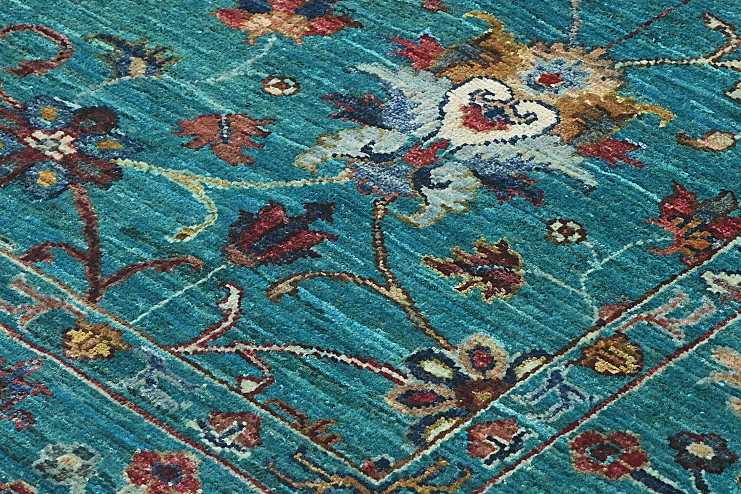Close-up of a patterned rug with floral designs on a blue background