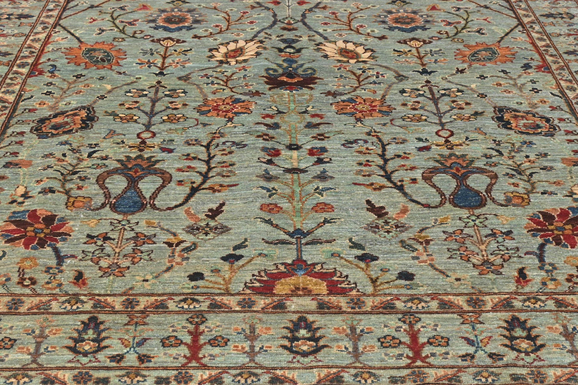 Close-up of a patterned rug with floral and botanical designs.