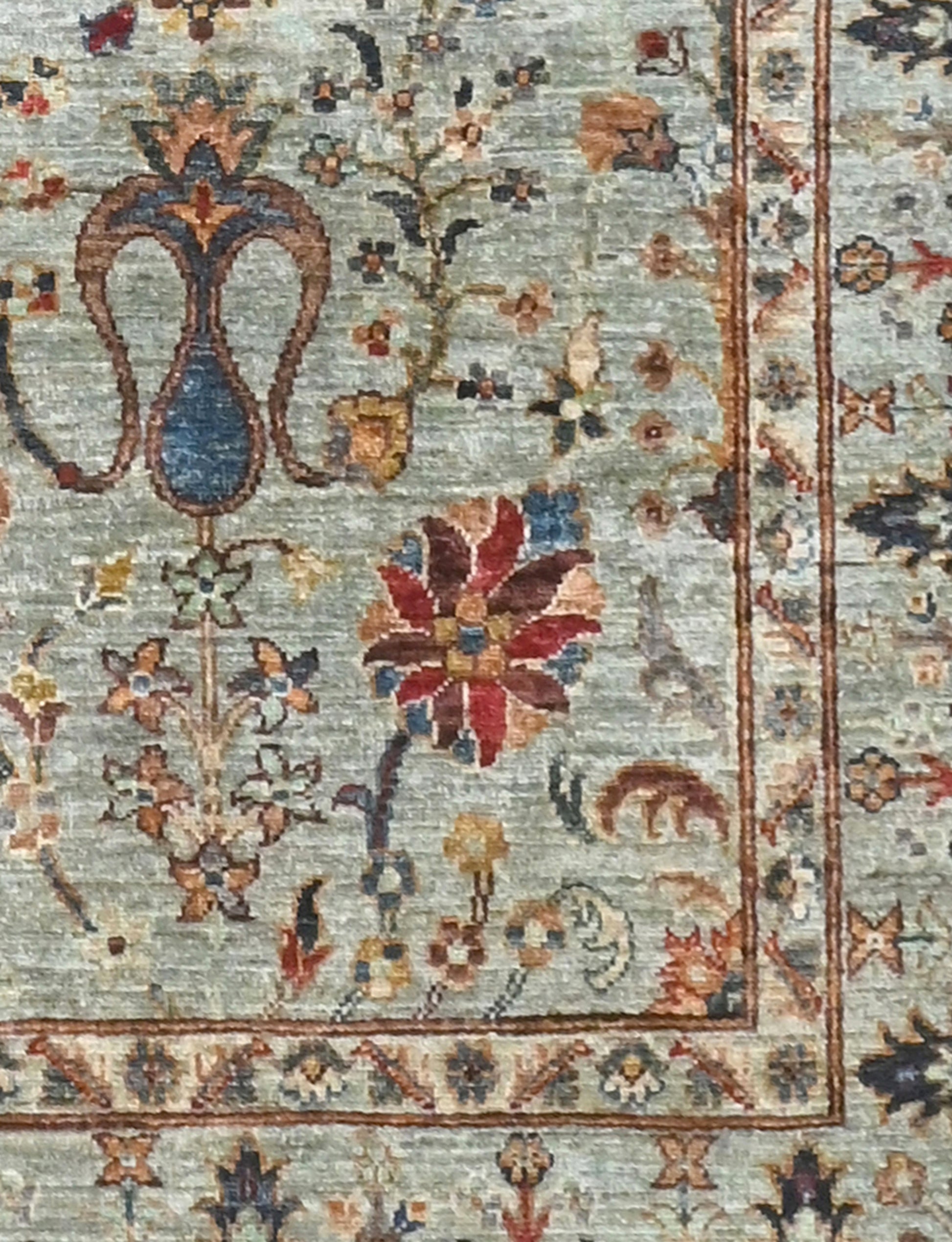 Decorative rug with intricate floral patterns and a border on a light blue background.