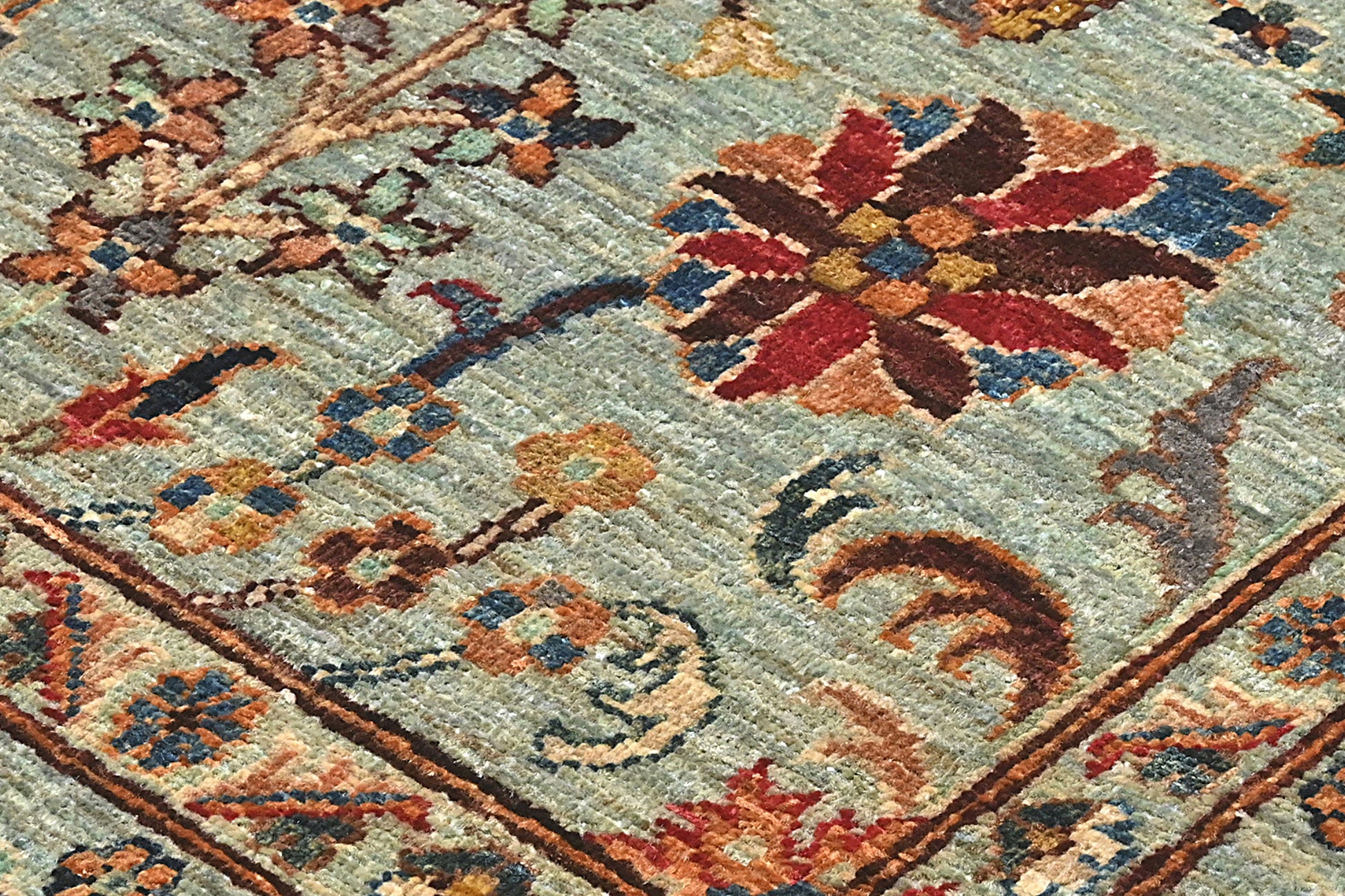 Close-up of a patterned rug with floral designs on a textured background