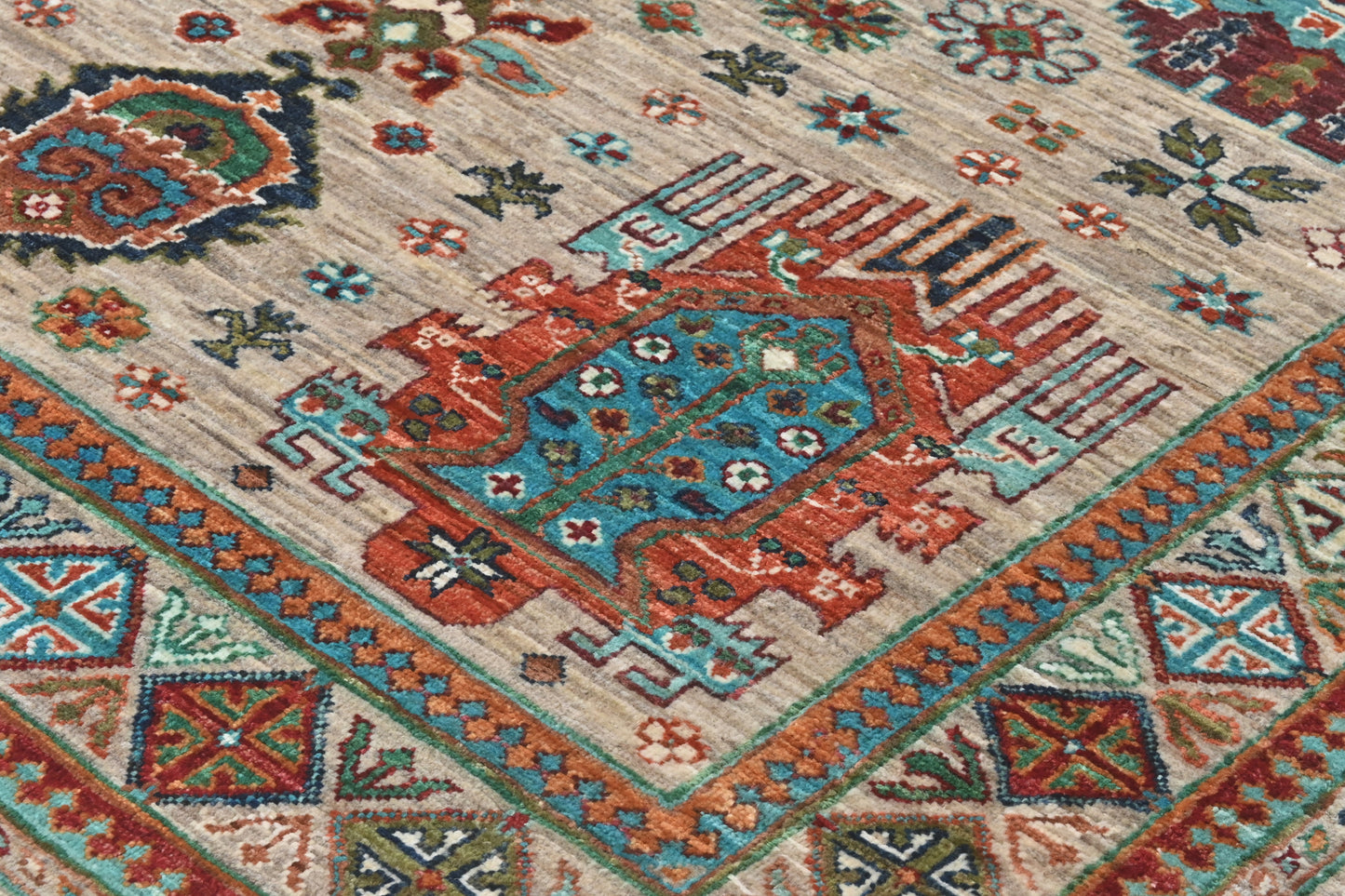 Close-up of a patterned rug with geometric designs in red, blue, and beige.