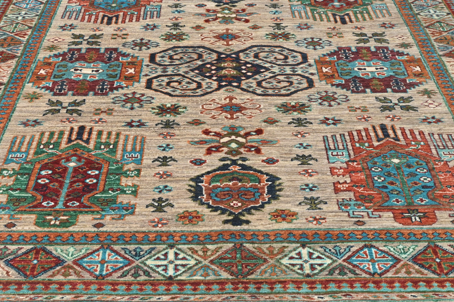 Close-up of a patterned rug with geometric designs in red, blue, and beige.