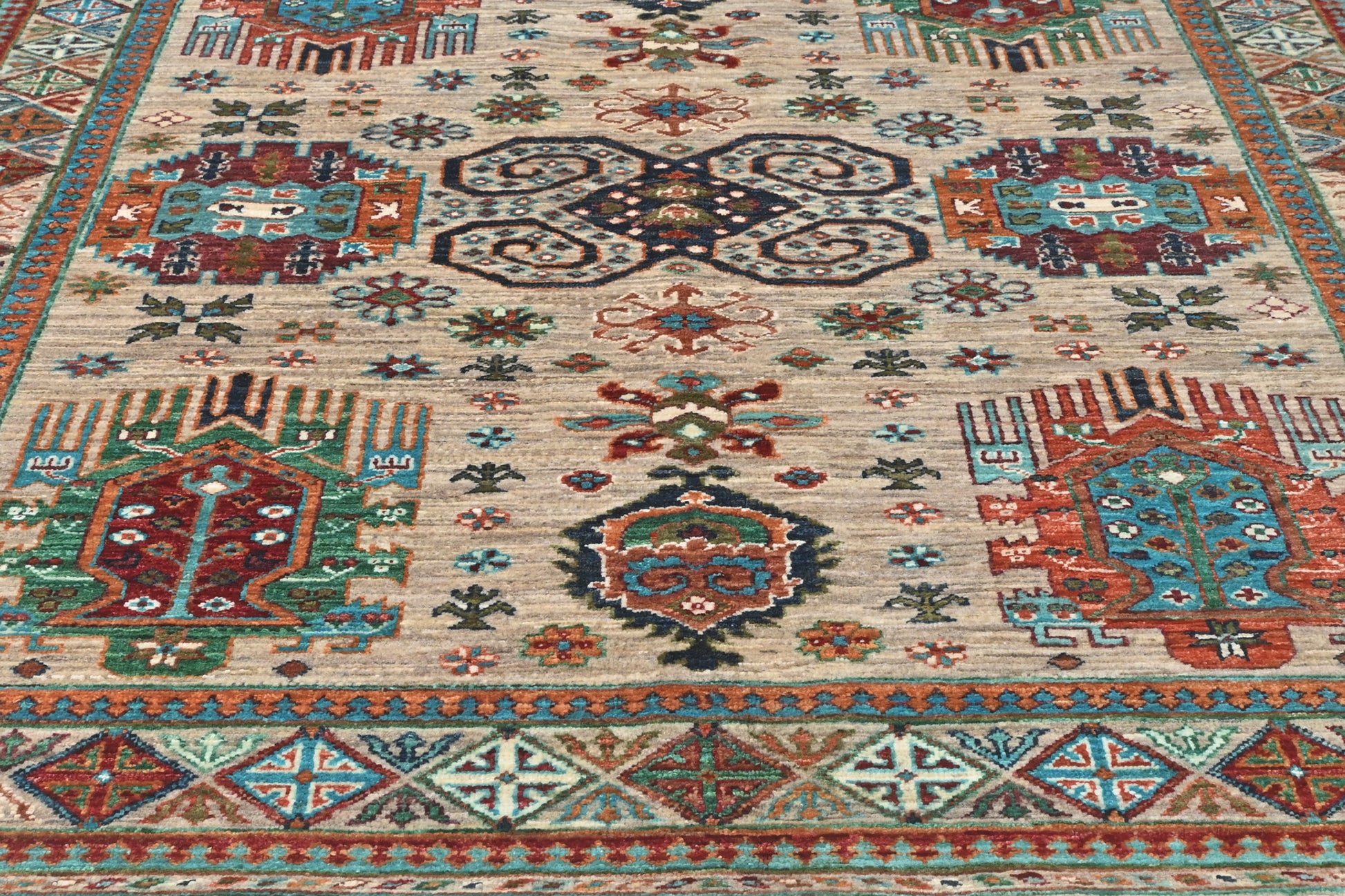 Close-up of a patterned rug with geometric designs in red, blue, and beige.