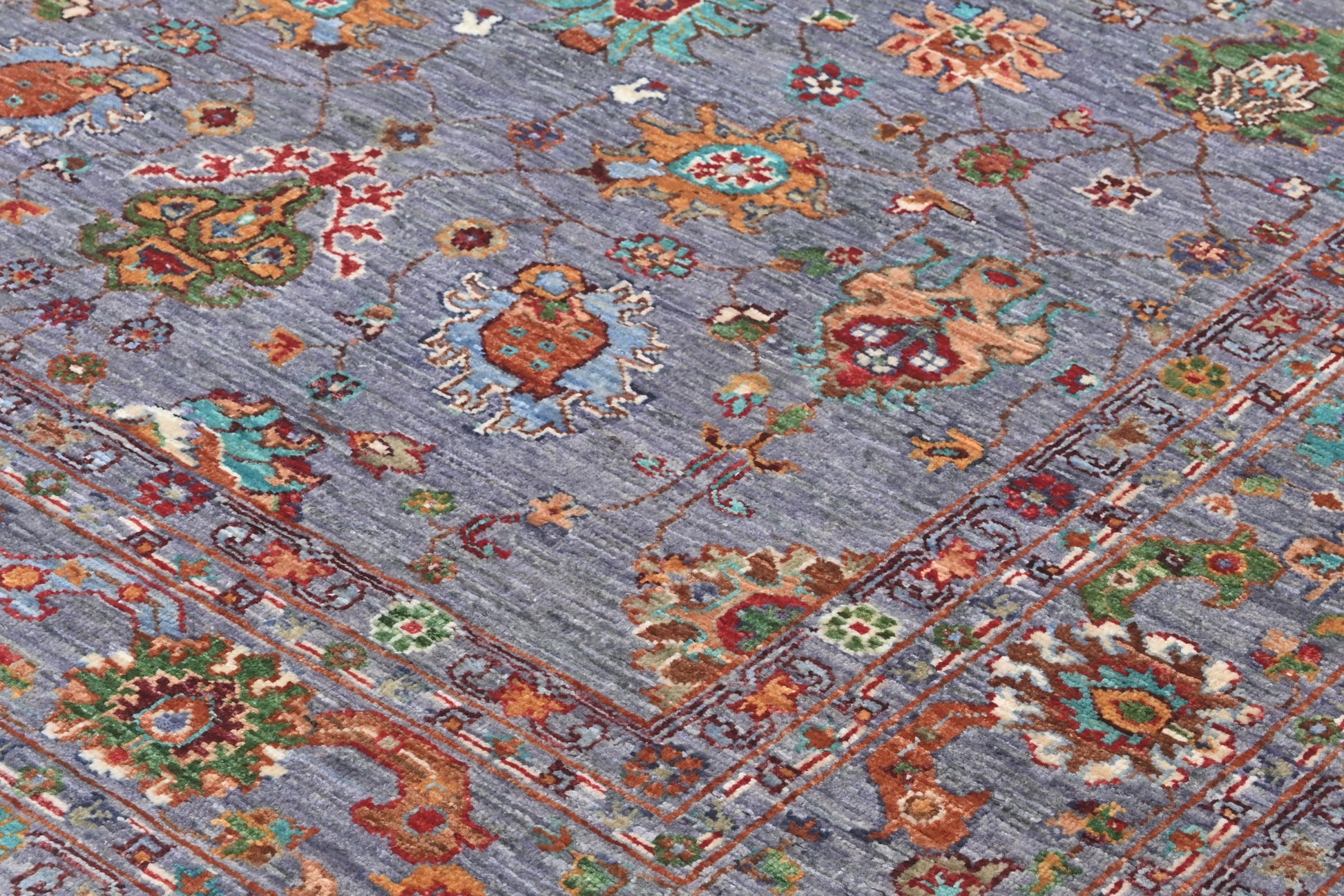 Close-up of a patterned rug with intricate designs on a blue background