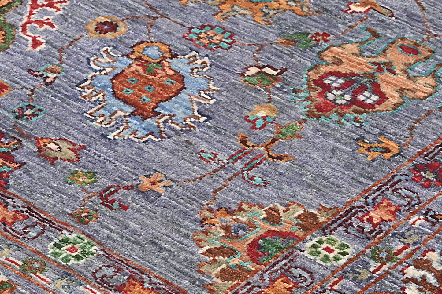 Close-up of a patterned rug with intricate designs on a blue background