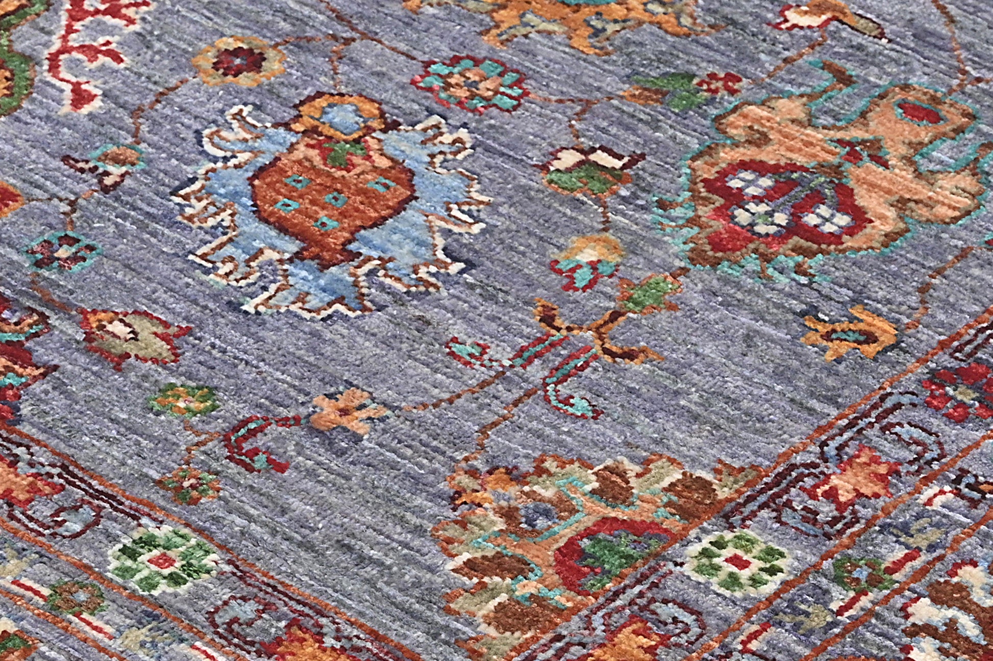 Close-up of a patterned rug with intricate designs on a blue background
