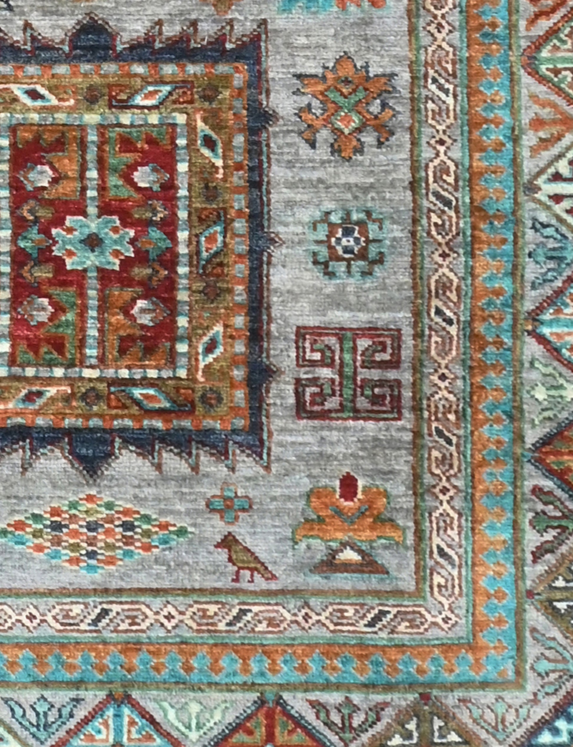 Close-up of a patterned rug with geometric designs in red, blue, and brown.