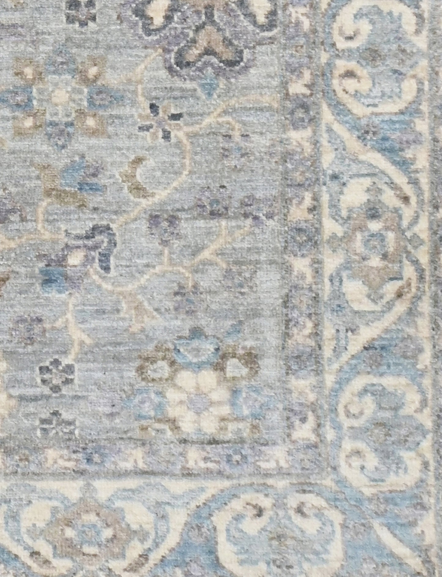 Decorative rug with intricate patterns in blue, beige, and gray on a textured background