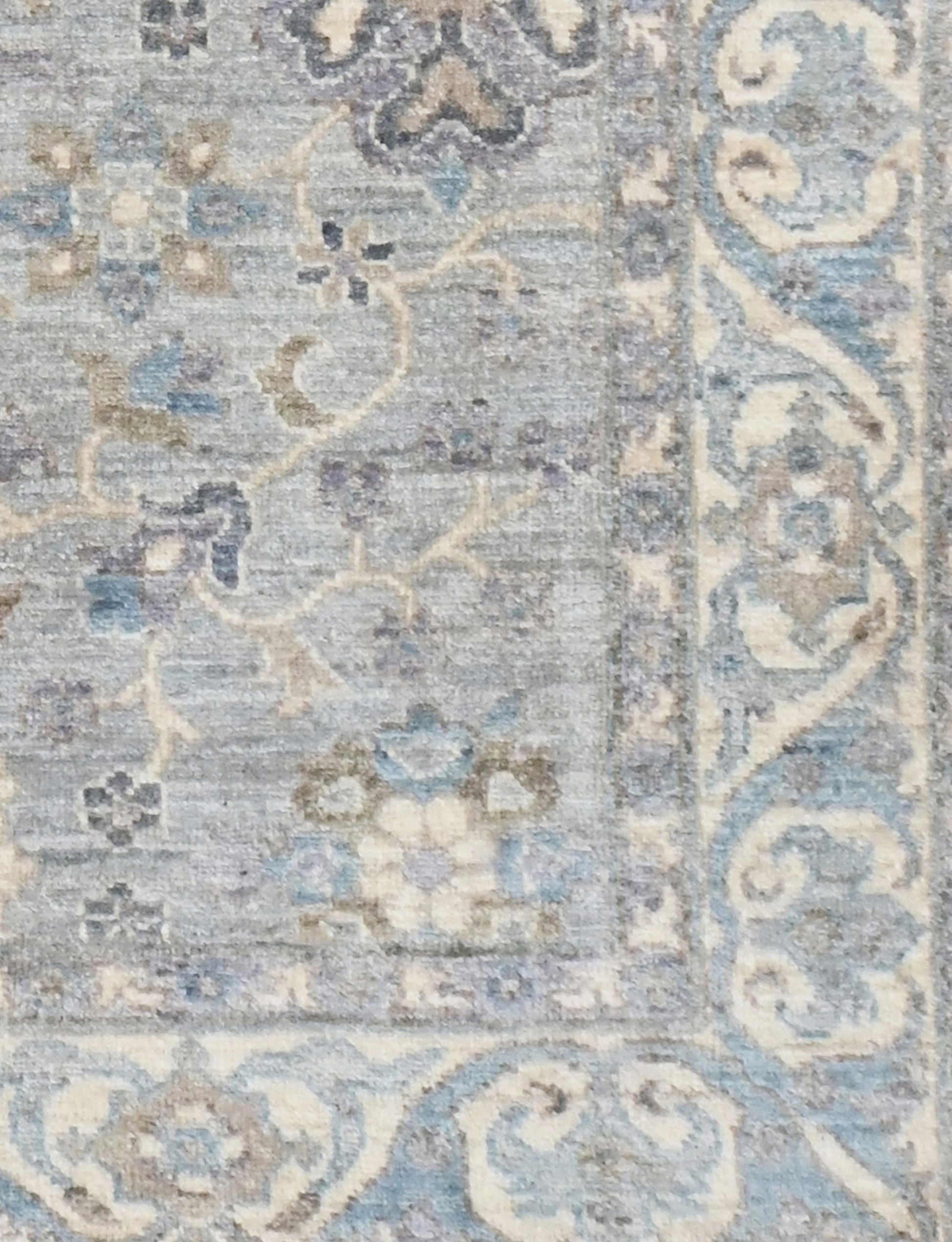 Decorative rug with intricate patterns in blue, beige, and gray on a textured background