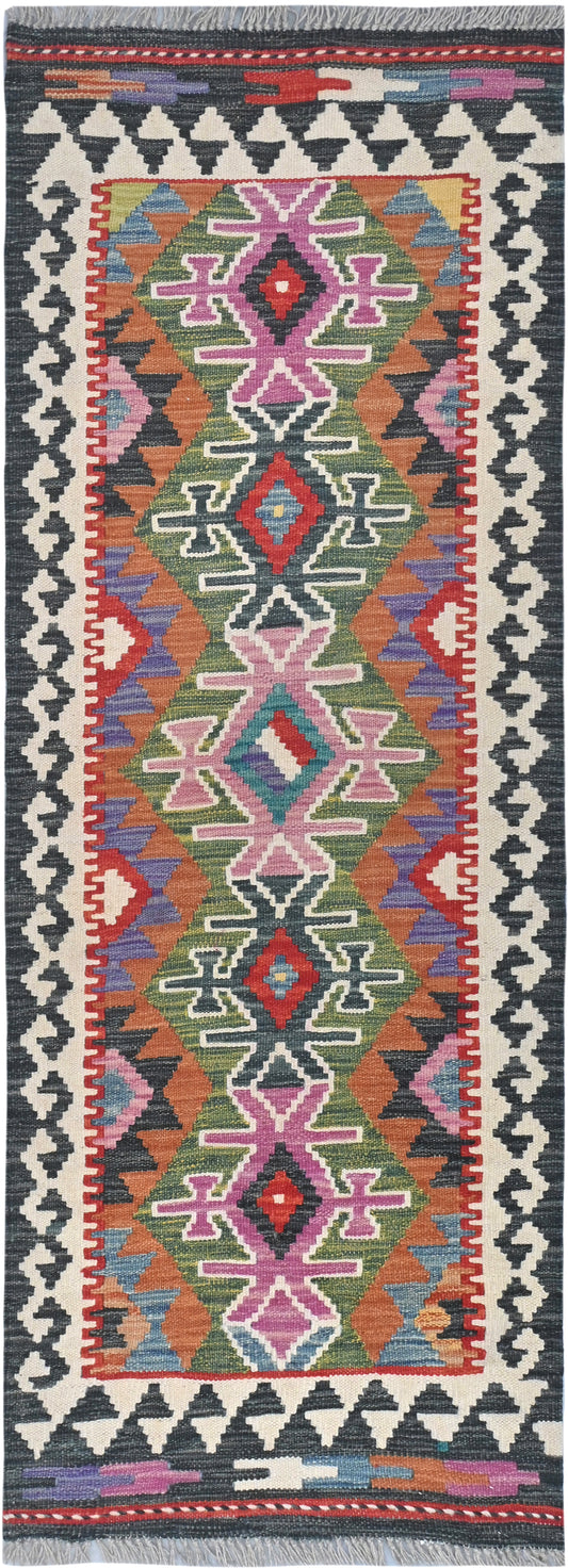 Colorful patterned rug with geometric design on a dark background