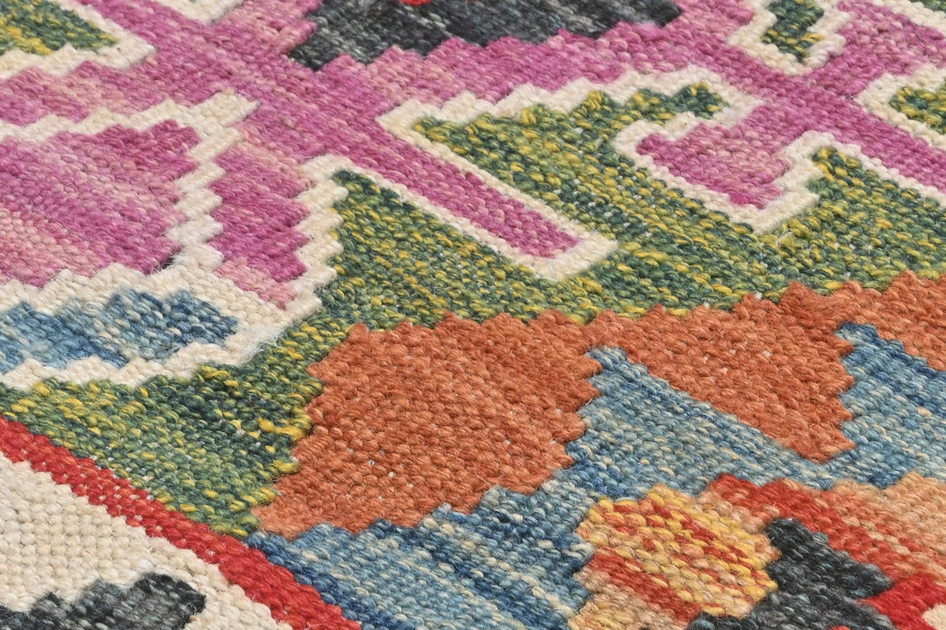 Close-up of a colorful geometric patterned rug with vibrant colors.