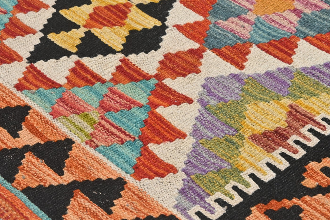 Close-up of a colorful geometric-patterned rug with vibrant colors.