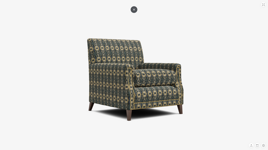 A single upholstered armchair with a geometric patterned fabric in muted green, beige, and gray tones, shown on a plain light gray background.