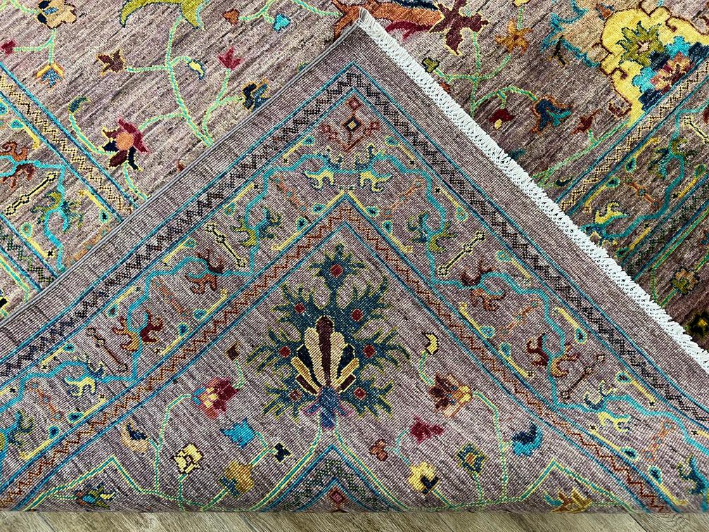 Close-up of a patterned rug with intricate designs on a wooden floor.