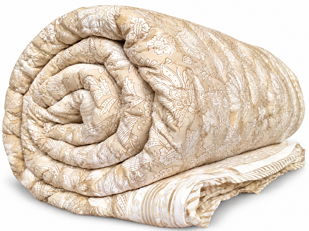 A rolled beige quilted comforter with an intricate floral damask pattern, displayed on a clean white background.
